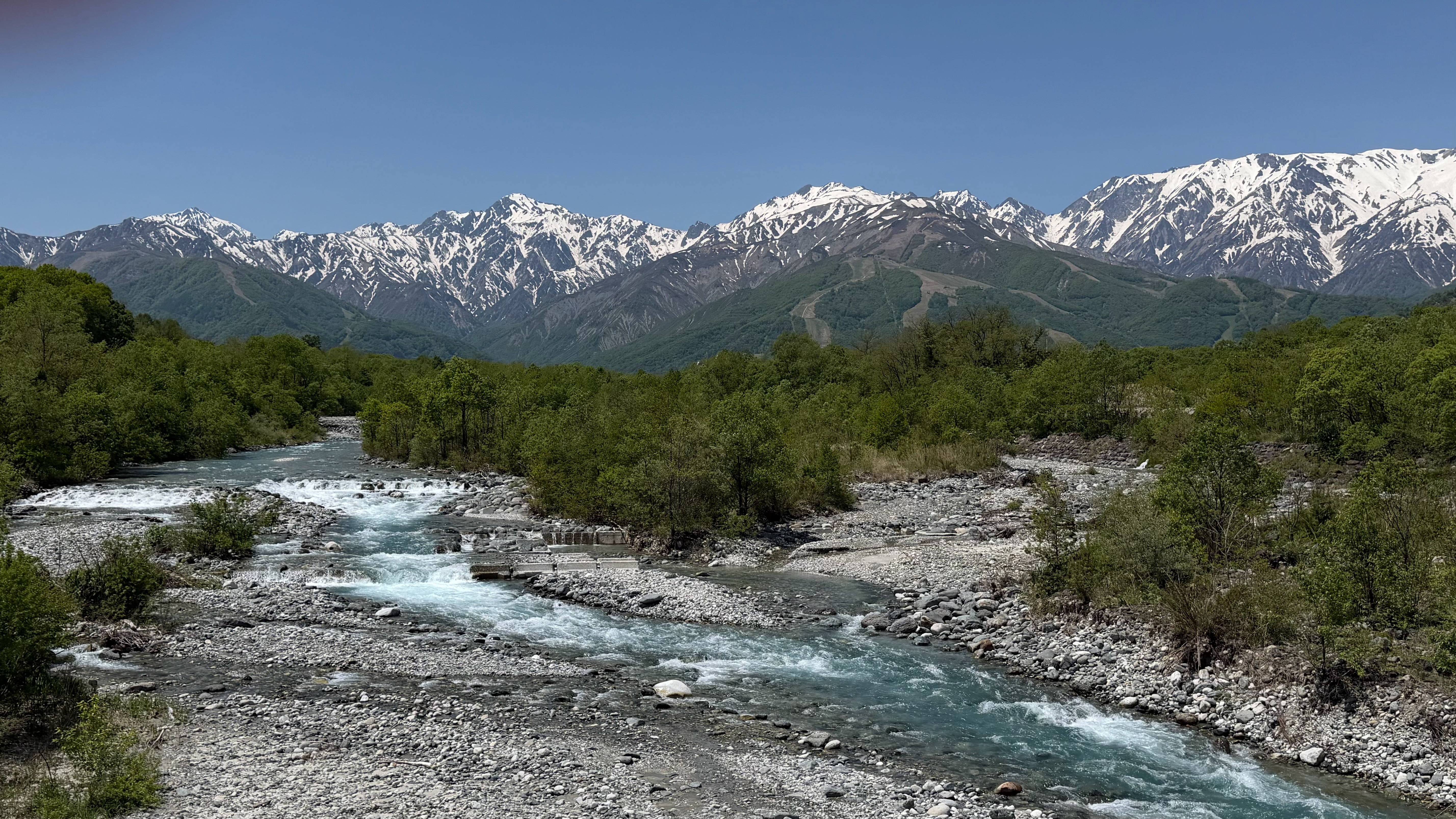 2026 North Alps — turquoise river and snow-capped Alps