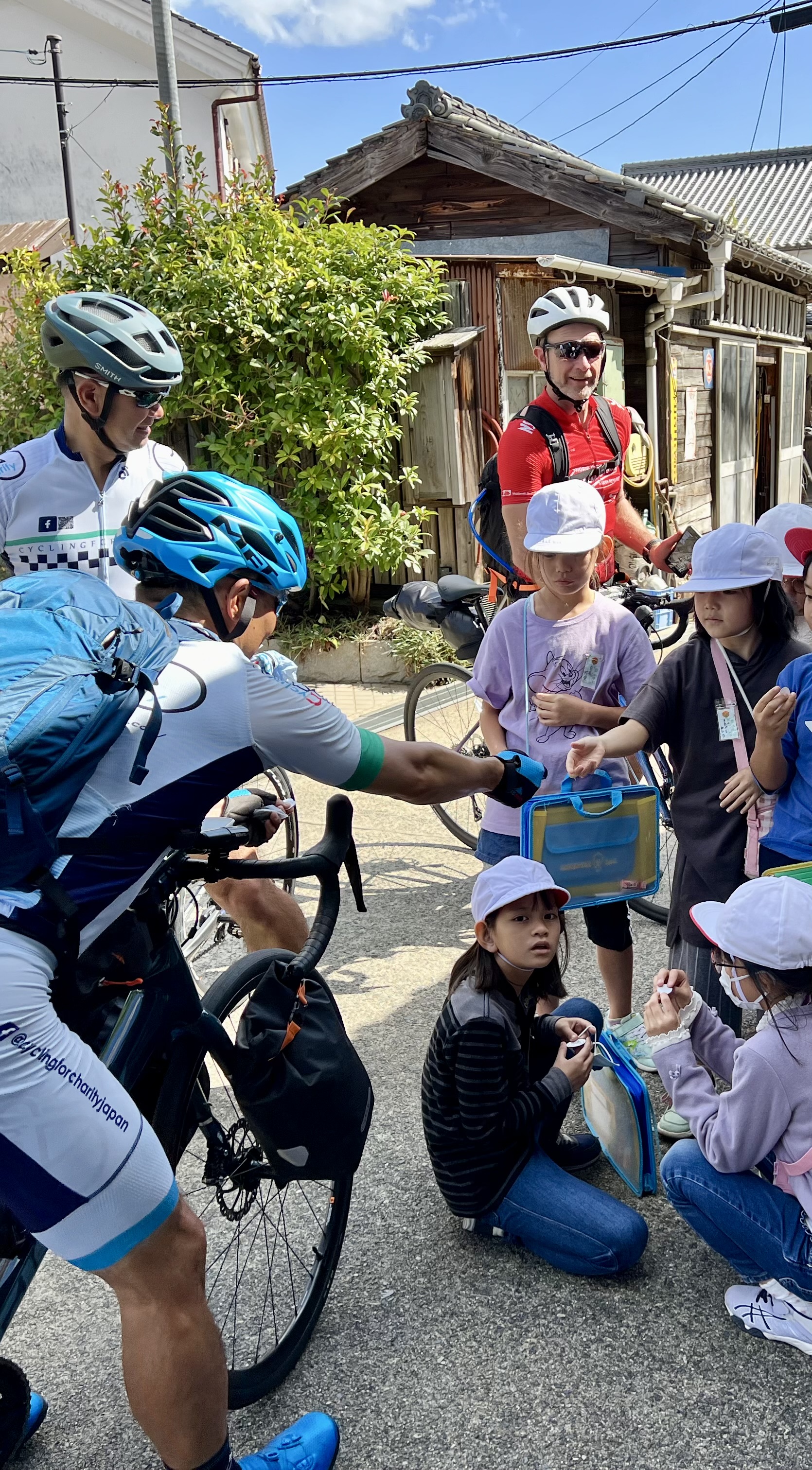 2023 riders with local children